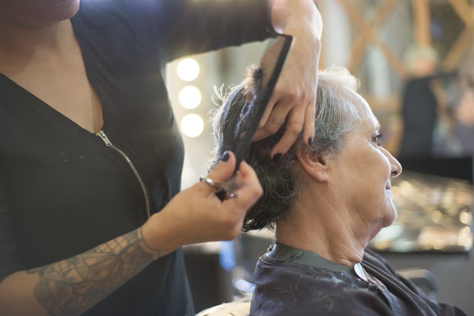 A hairdresser giving a stylish haircut to a senior woman in a warm and friendly salon environment